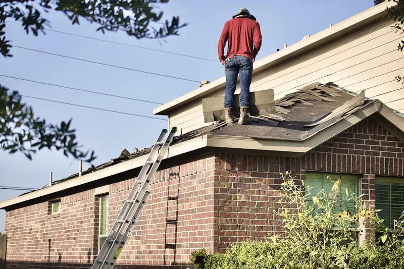Professional roofer working on a residential roof in Audubon South
